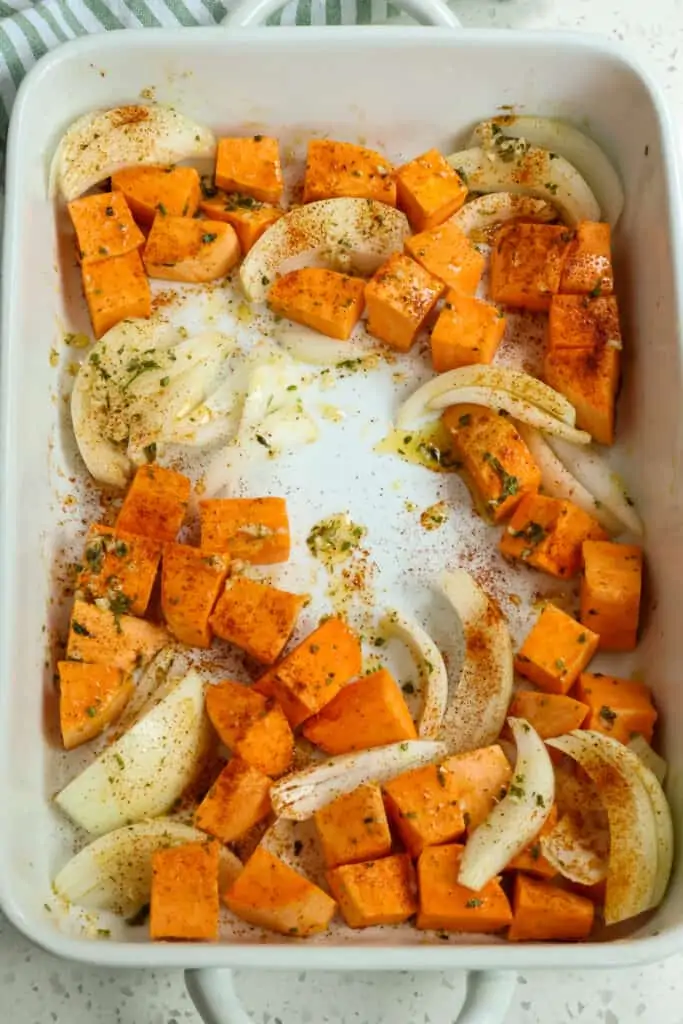 Then add the sweet potatoes and onions to the baking dish.  Brush a little of the olive oil mixture over the vegetables using a basting brush. 