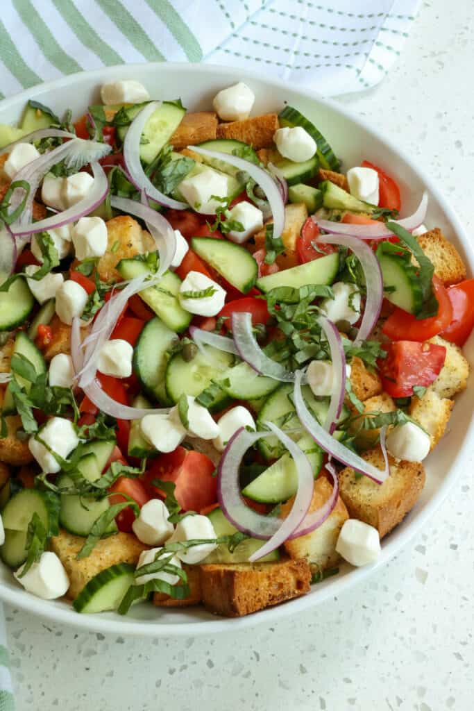 Panzanella is a popular summer bread and tomato chopped salad that often includes cucumber and is usually dressed with an oil and vinegar dressing