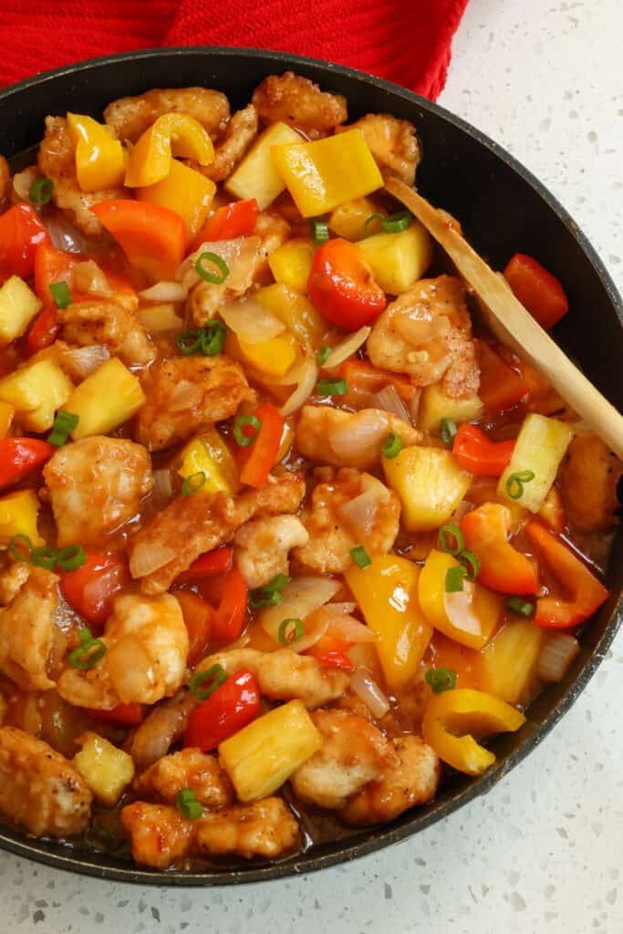 This tasty Pineapple Chicken combines crispy fried chicken pieces with pineapple, bell peppers, onions, garlic, and green onions in a sweet ginger pineapple sauce.