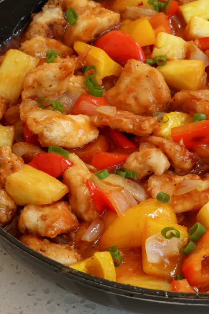 A quick and easy Pineapple Chicken Recipe with fresh pineapple, orange and red bell peppers, onions, and garlic all in a lightly sweetened pineapple sauce.