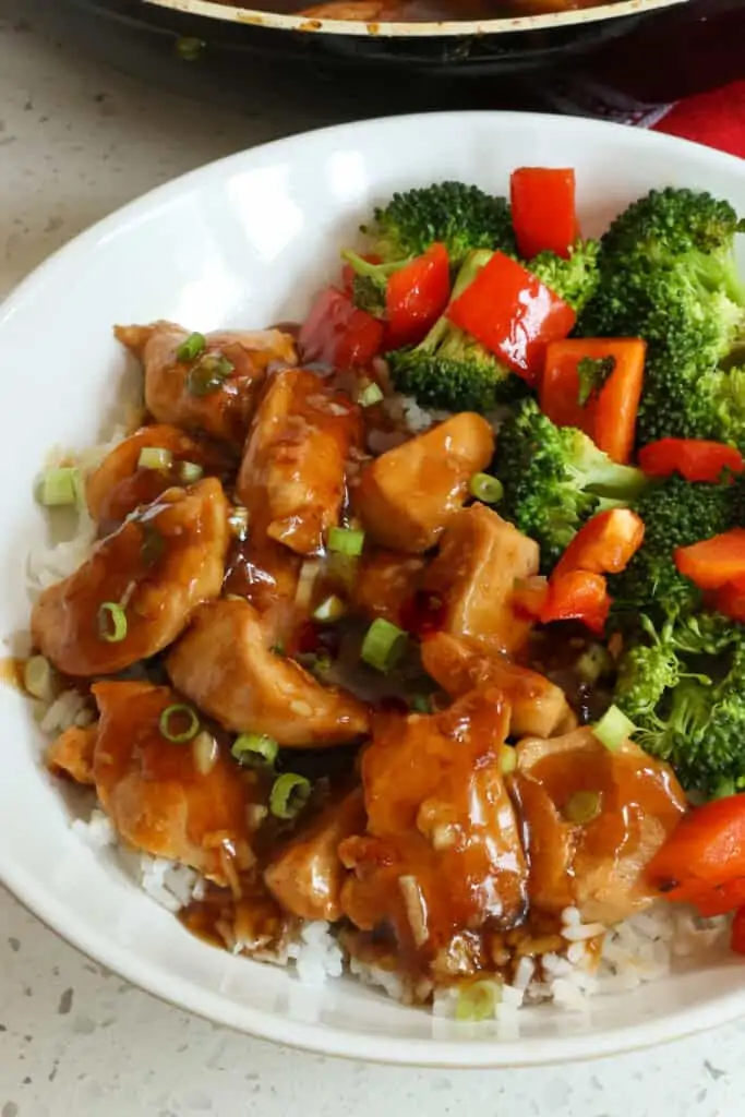 Easy Teriyaki Chicken Bowls are tender chicken pieces in teriyaki sauce over rice with stir fried broccoli and red bell pepper.