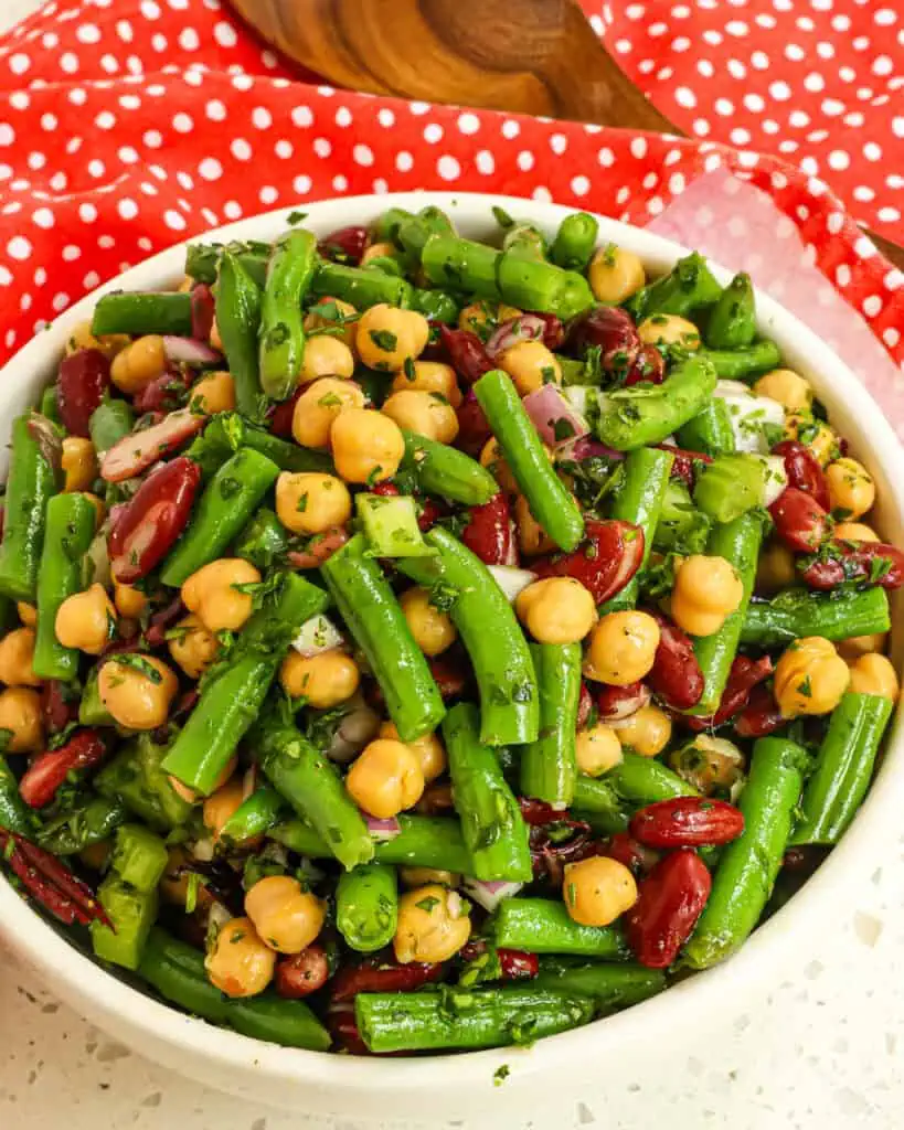An overhead view of a serving bowl full of three bean salad. 