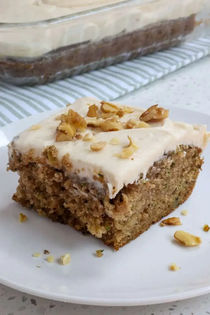 This scrumptious and moist zucchini cake is flavored with fresh zucchini, walnuts, cinnamon, and nutmeg. It is all topped with an easy four ingredient cinnamon cream cheese frosting.