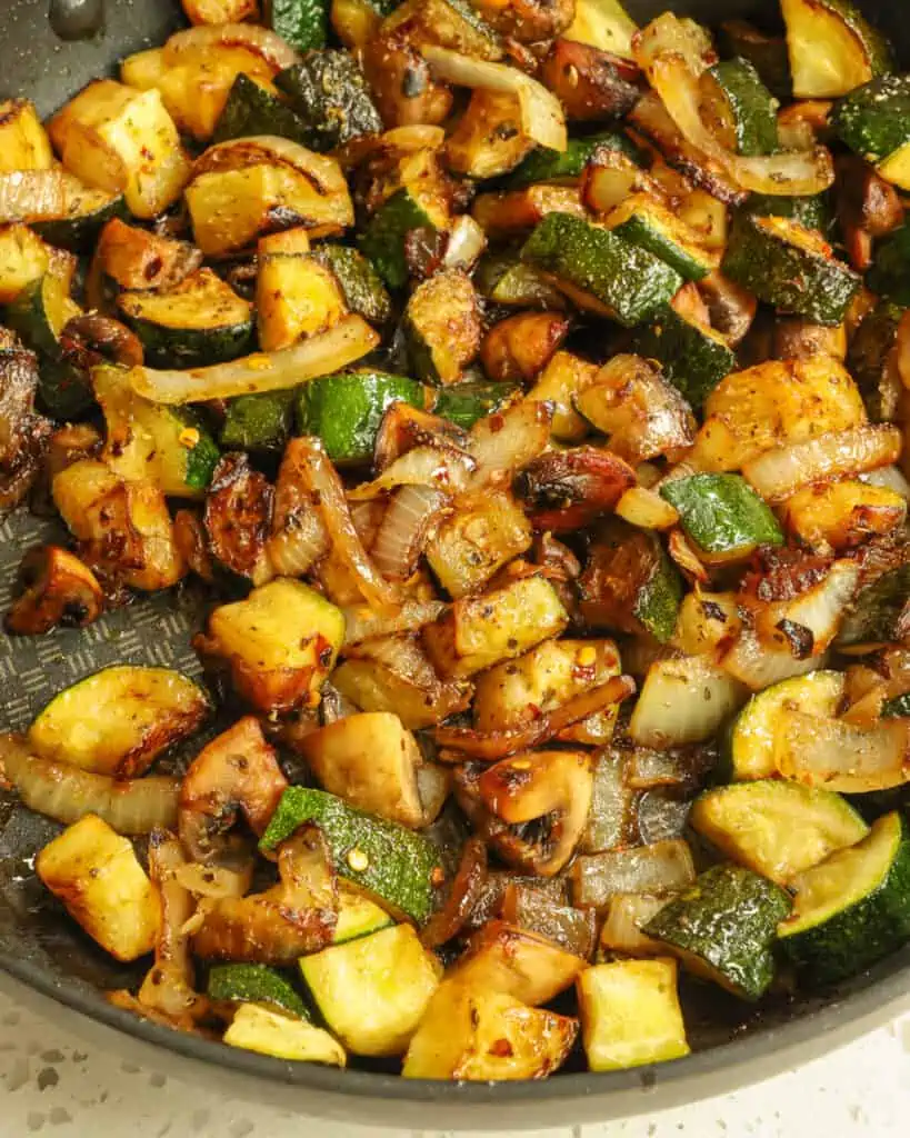 Reduzieren Sie die Hitze und geben Sie Knoblauch, italienische Gewürze und rote Pfefferflocken hinzu. Für ein optimales Ergebnis servieren Sie das Gericht sofort.