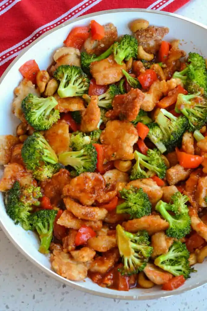 A skillet full of cashew chicken with broccoli, red pepper, and cashews.  
