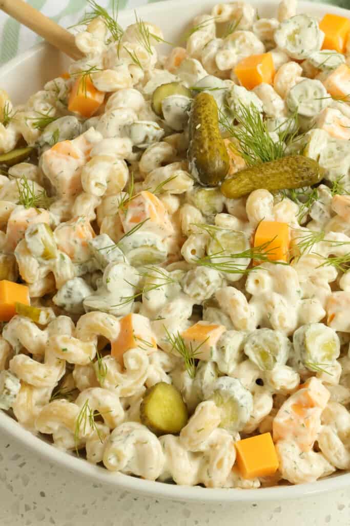 Quick and easy Dill Pickle Pasta Salad combines cellentani pasta, dill pickles, sharp cheddar, and fresh dill in a creamy mayonnaise and sour cream base. 