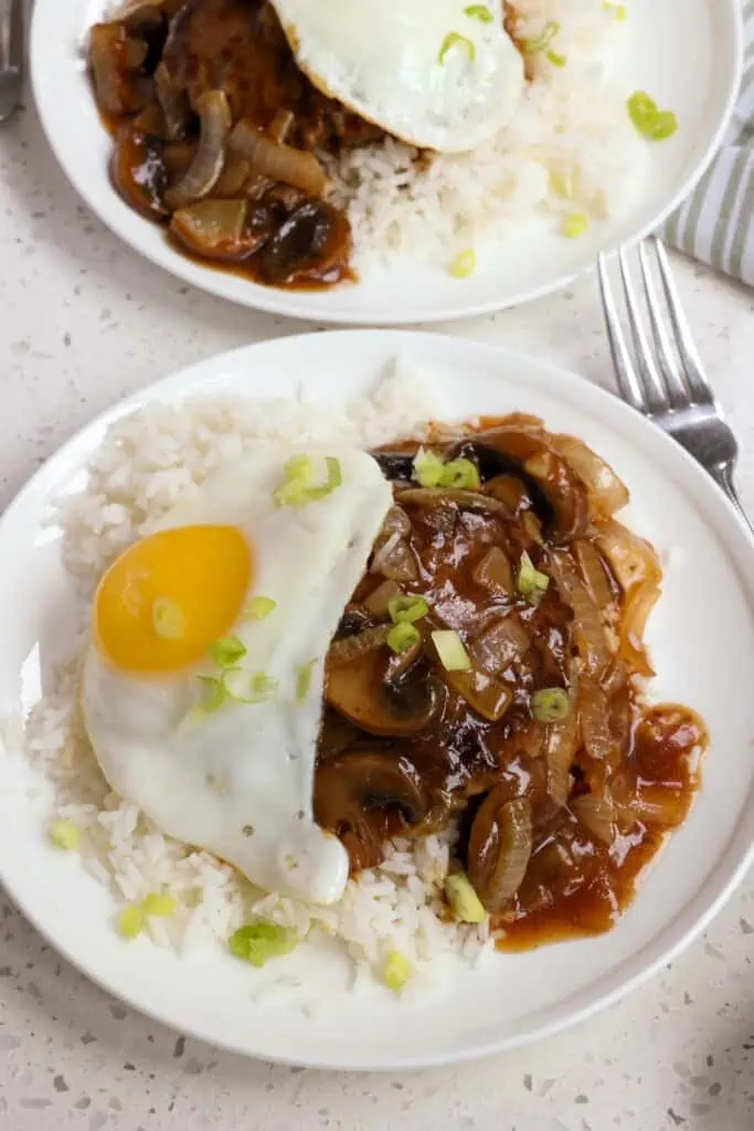 This Hawaiian Loco Moco recipe is pan fried hamburger patties over white rice smothered with a mushroom onion brown gravy and a sunny side up fried egg. 