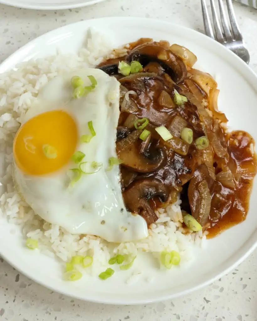This classic Loco Moco is a pan fried hamburger patty over white rice drenched in an onion and mushroom brown gravy and topped with a fried egg. 