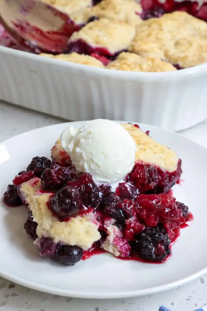A delicious mixed Berry Cobbler with blackberries, blueberries, and raspberries all baked up juicy with a flaky buttery biscuit topping. 