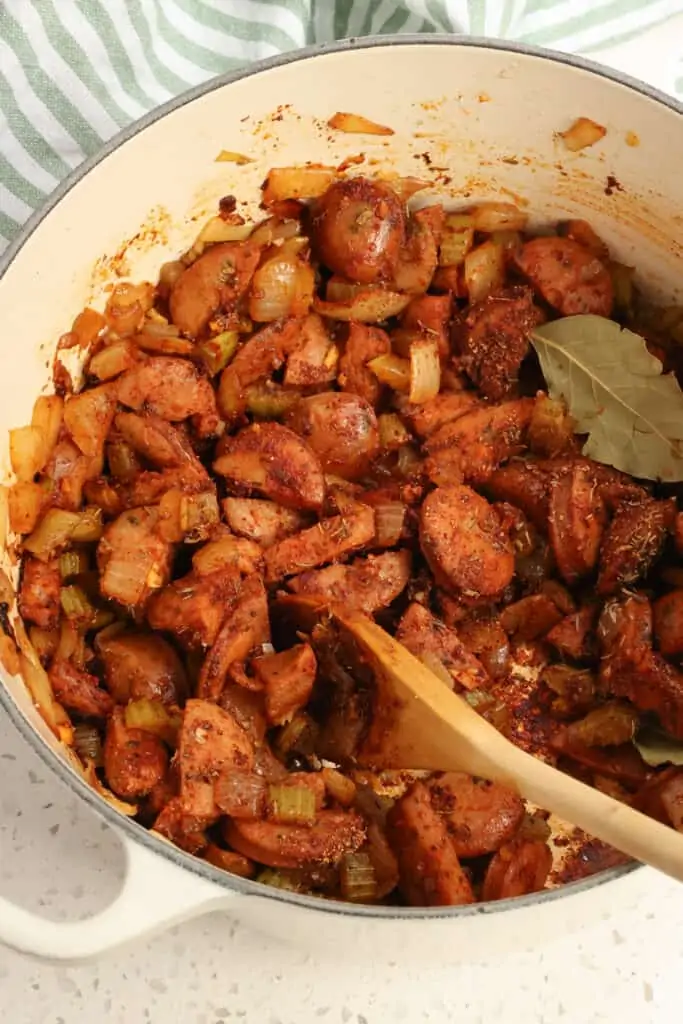 Cook until the onions and celery are soft and the sausage is browned. Reduce the heat to low and add the garlic, paprika, chili powder, thyme, marjoram, and cayenne pepper.