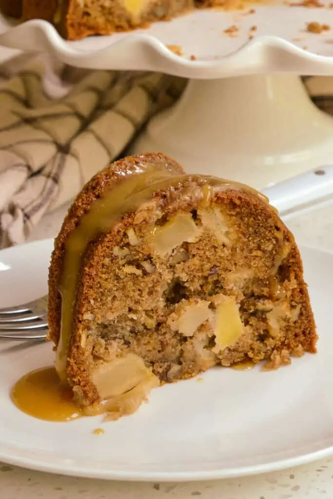 A piece of apple cake with chunks of apple baked in it and a caramel drizzle. 