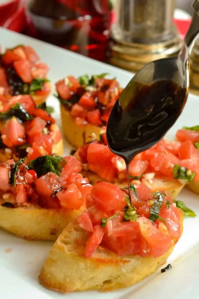 An easy garden fresh bruschetta recipe combining sun ripened tomatoes, sweet basil, and garlic all served on toasted baguette slices with a drizzle of balsamic glaze.