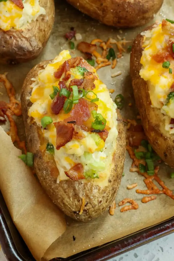 These crispy skinned Loaded Baked Potatoes are packed with bacon, broccoli, and sour cream all topped with a generous portion of cheddar cheese and Monterey Jack Cheese and sprinkled with thin slices of green onions.