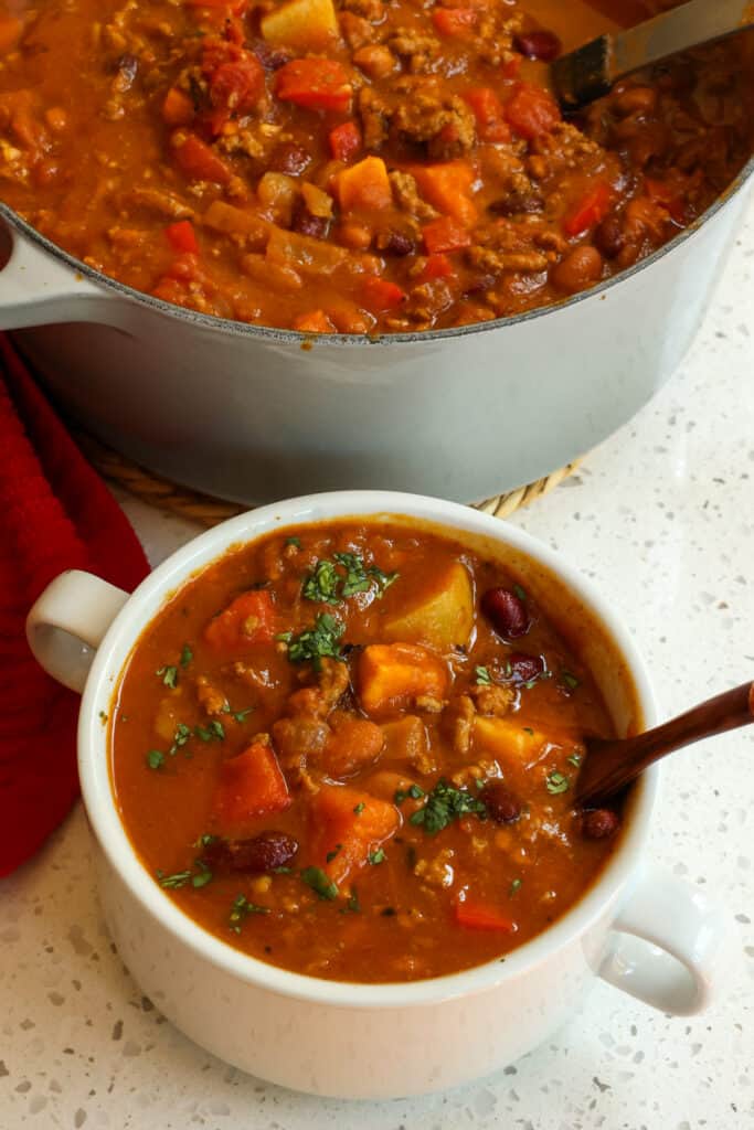 Deliciously different and surprisingly tasty Pumpkin Chili made with ground beef, red  bell peppers, sweet potatoes, fire roasted tomatoes, and of course pumpkin puree all in a perfect blend of spices with a touch of cinnamon. 