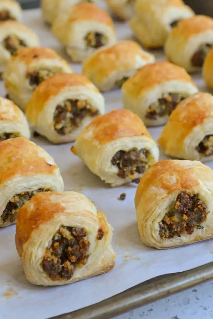 These sausage rolls combine buttery puff pasty stuffed with browned sausage, onion, a touch of Dijon mustard, and parsley.