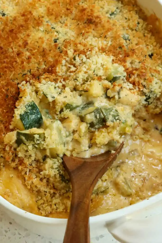 A fresh zucchini casserole with sautéed onions and garlic in a creamy cheese sauce topped with buttery Parmesan Panko breadcrumbs.