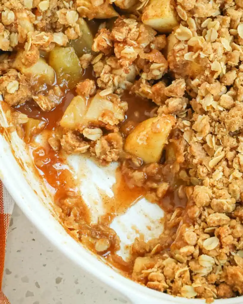 A close up view of apple crumble in a casserole dish.