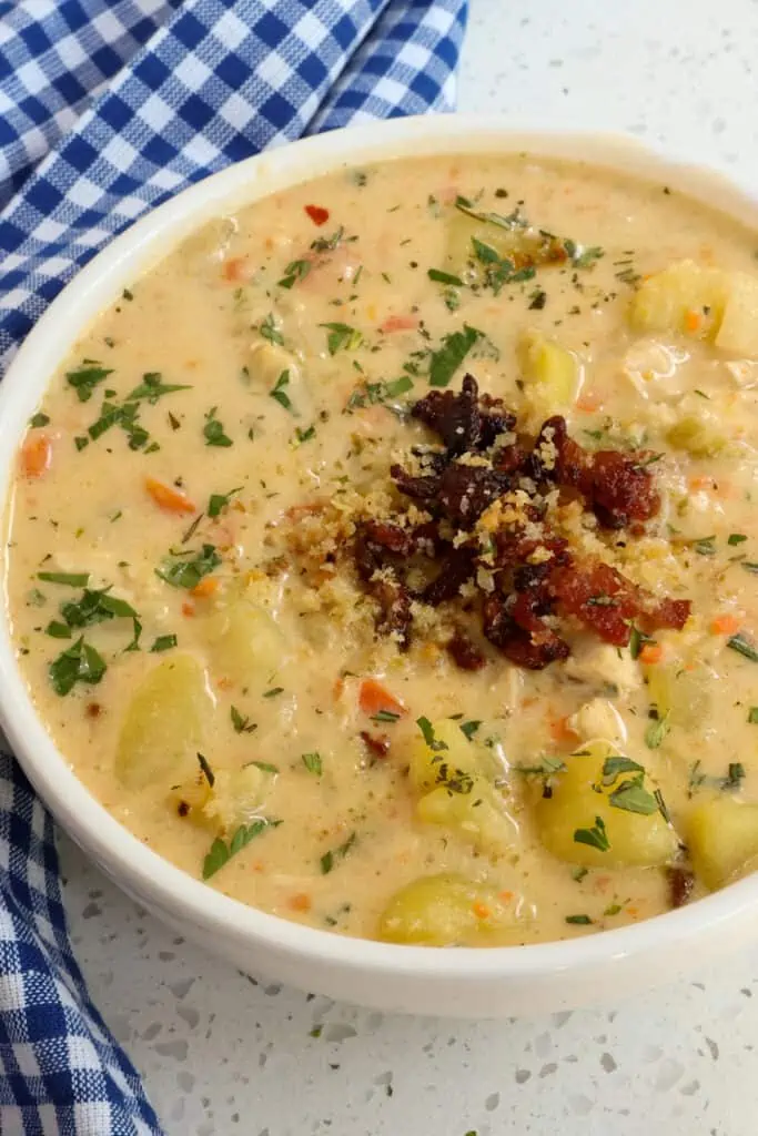 This Creamy Chicken Potato Soup recipe combines onions, carrots, celery, potatoes, and cooked rotisserie chicken in a creamy cheddar broth seasoned with thyme and rosemary.