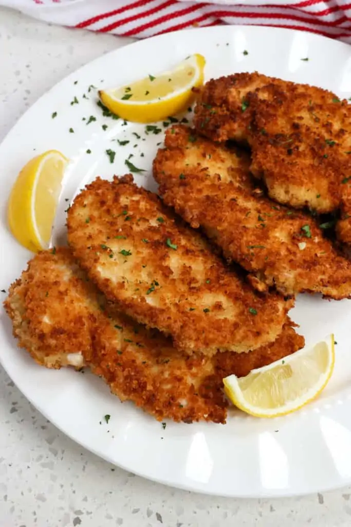 Crispy Chicken Schnitzel are breaded chicken cutlets that are pan fried to golden crispiness and served with a spritz of lemon and chopped fresh parsley or dill.