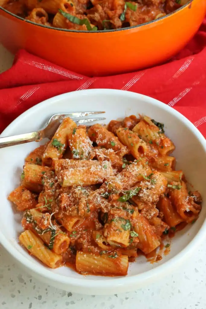 Slow simmered classic Italian Pasta Bolognese sauce with pancetta, ground beef, onions, carrots, celery, and tomatoes over al dente pasta and sprinkled with fresh thyme and basil.