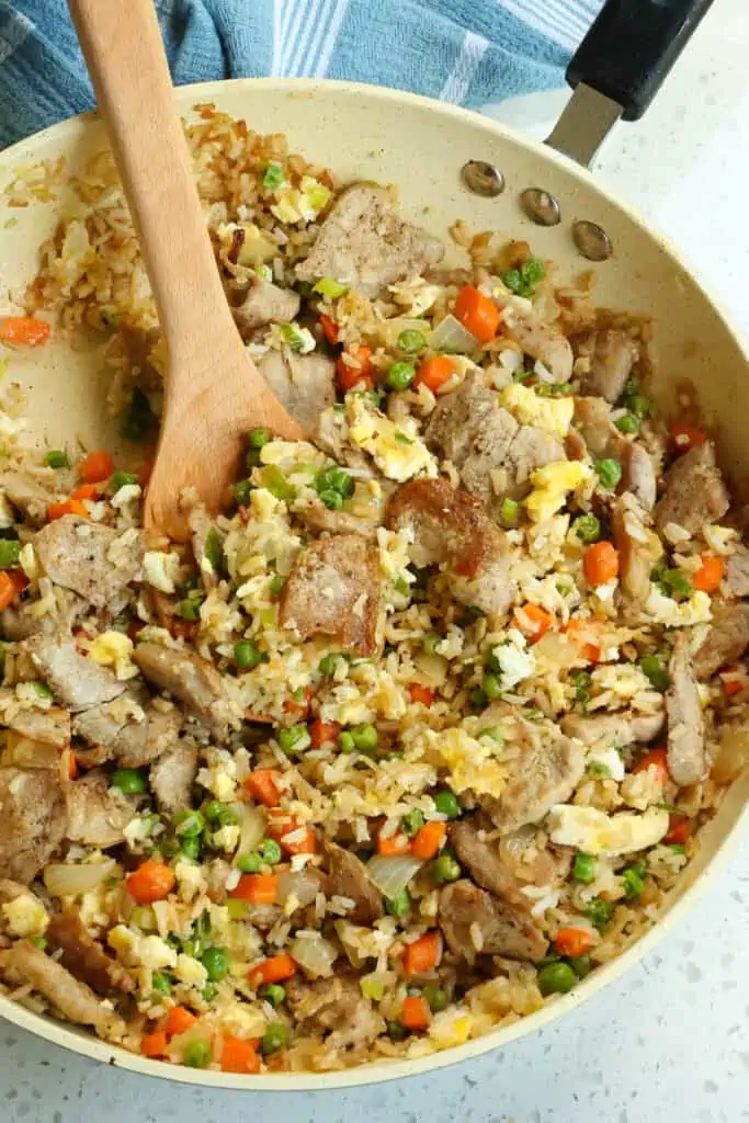 This easy Pork Fried Rice Recipe combines bite sized pieces of pork tenderloin with onion, peas, carrot, garlic, ginger, rice and eggs all stir fried to perfection in a few simple steps. .