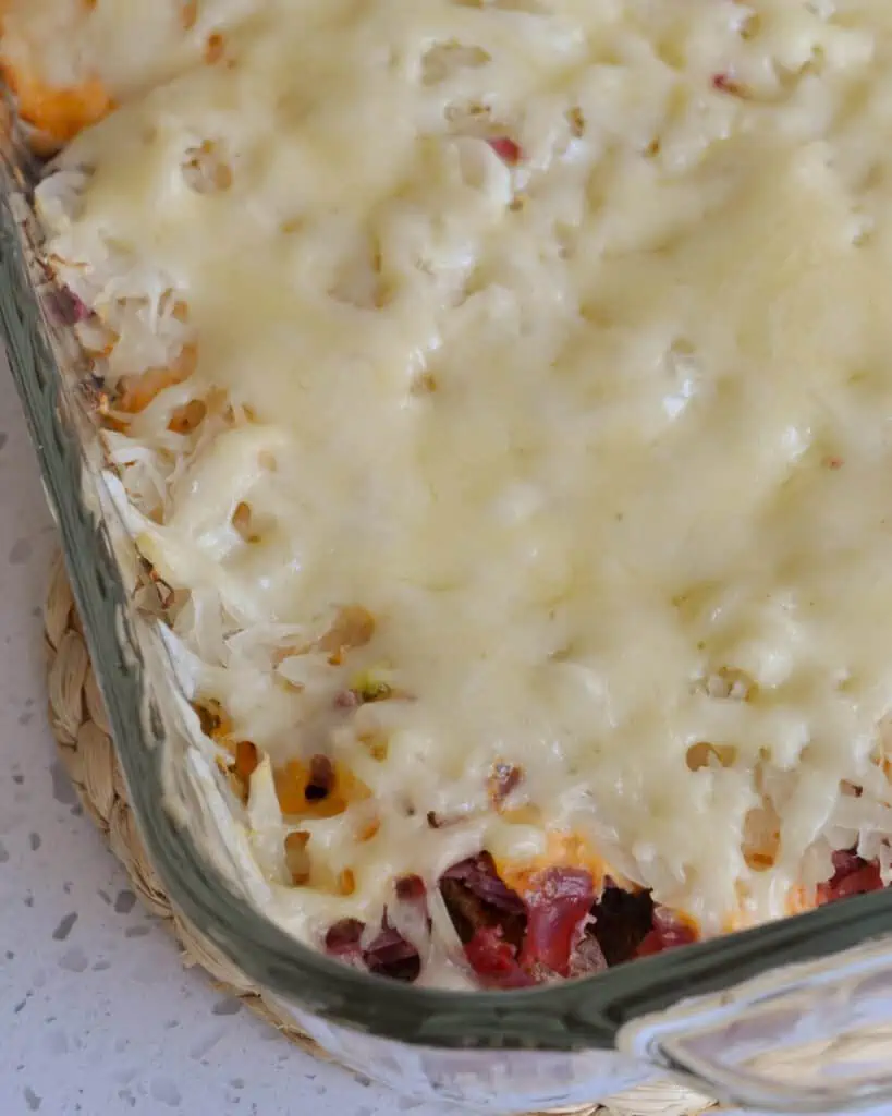 This Reuben Casserole is topped with creamy melted swiss cheese on top of layers of sauerkraut and corned beef