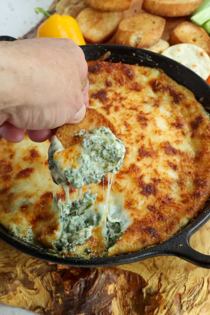 This easy Hot Spinach Dip combines fresh sautéed spinach, Parmesan Cheese, and mozzarella cheese into a smooth and creamy blend of cream cheese, mayonnaise, and sour cream.  