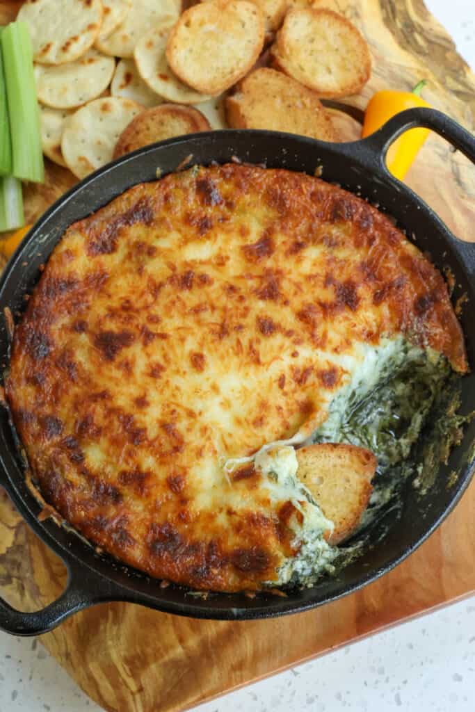 A crowd-pleasing creamy Hot Spinach Dip made with three kinds of cheese, mayonnaise, sour cream, and Parmesan Cheese all baked to golden perfection 
