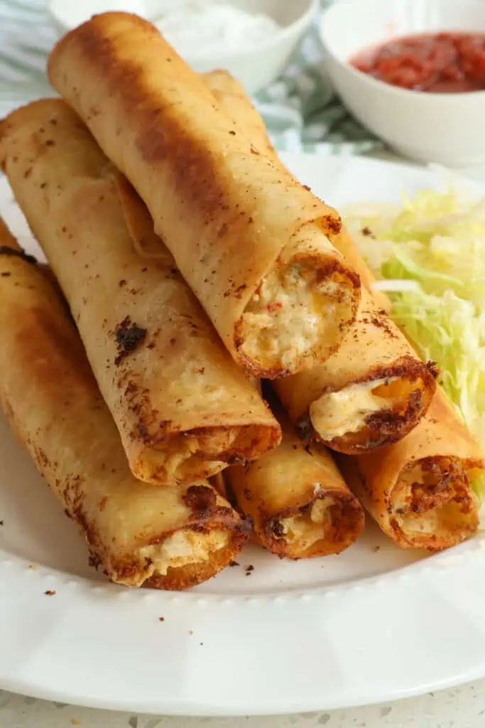These creamy Chicken Taquitos are loaded with cream cheese, sour cream, diced cooked chicken, shredded cheddar cheese, and shredded pepper jack cheese all fried to golden crisp perfection in a flour or corn tortilla.