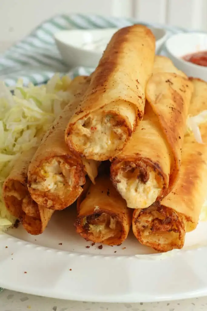 So much better than boxed creamy homemade Chicken Taquitos with cream cheese, sour cream, diced chicken,  cheddar cheese, and pepper jack cheese all with the perfect blend of spices.