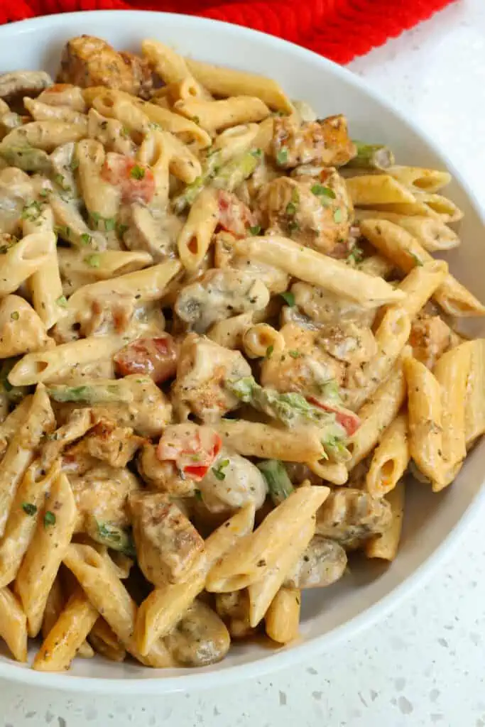 This Cajun Chicken Pasta is plump full of chicken pieces coasted with Cajun seasoning, mushrooms, red bell pepper, and asparagus all in a creamy Parmesan sauce seasoned with a little more Cajun seasoning.