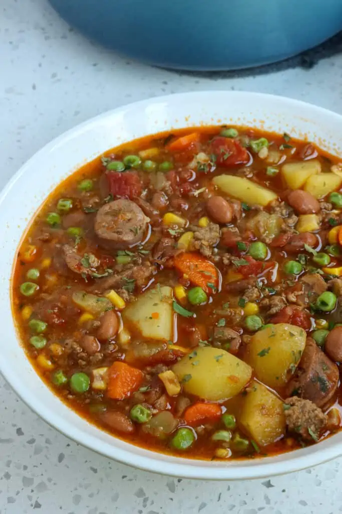 Cowboy stew is a cornucopia of fabulous flavors from crisp bacon, browned ground beef, and Kielbasa smoked sausage all combined with hearty veggies and beans in a tomato-based broth seasoned with chili powder, cumin, and smoked paprika.