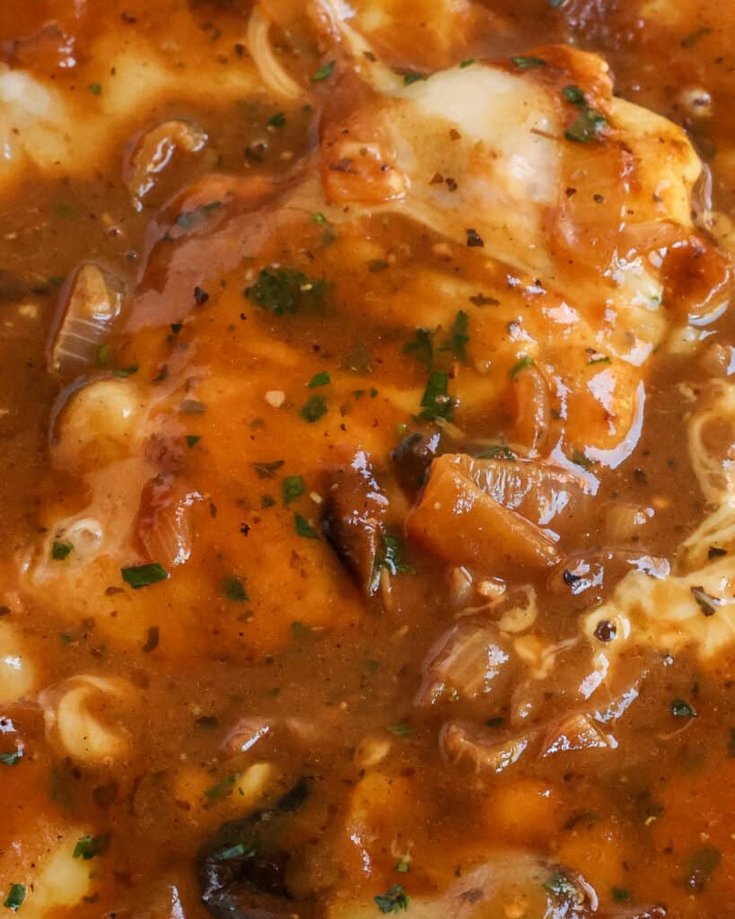 Il pollo alla cipolla francese è una cotoletta di pollo cotta in un colore marrone dorato e cotta a fuoco lento in salsa di cipolle e condita con parmigiano grattugiato fresco e formaggio svizzero tutto fuso alla perfezione.