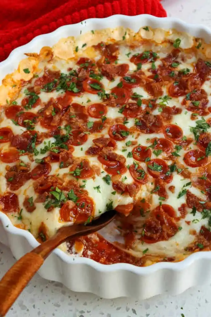 A quick and easy party favorite Pizza Dip made with cream cheese, mozzarella cheese, grated Parmesan cheese, a few common pantry spices, pepperoni, and bacon.