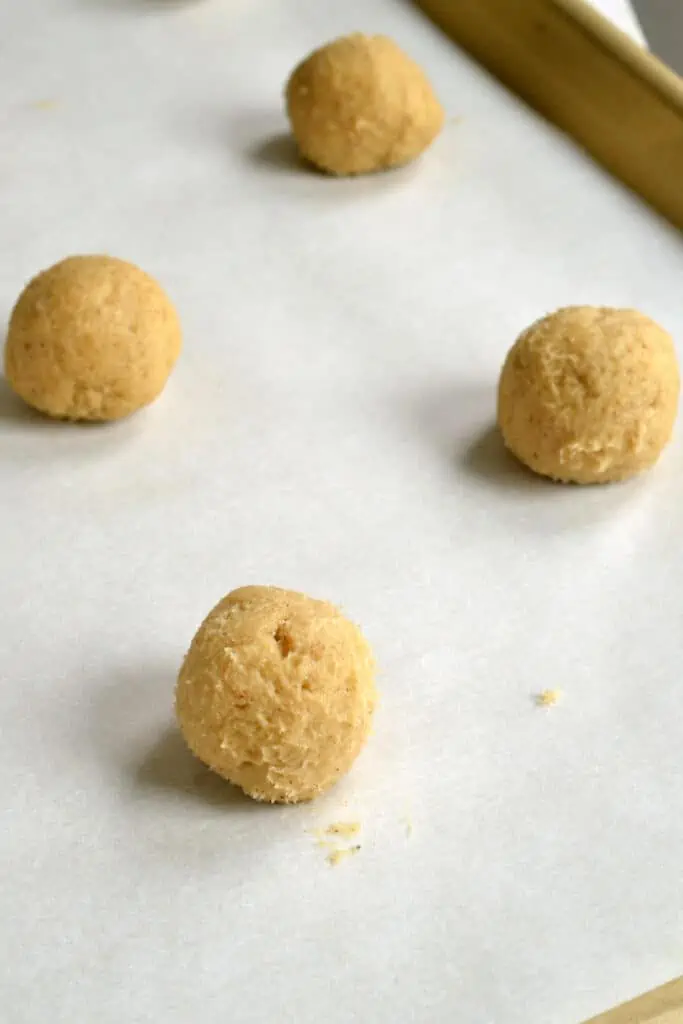 lightly butter your hands and roll the cookie dough into a little less than 1-inch balls. 