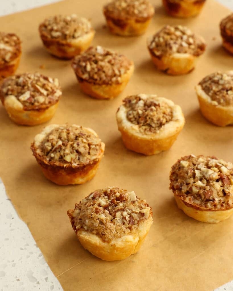 Pecan tassies on parchment paper.
