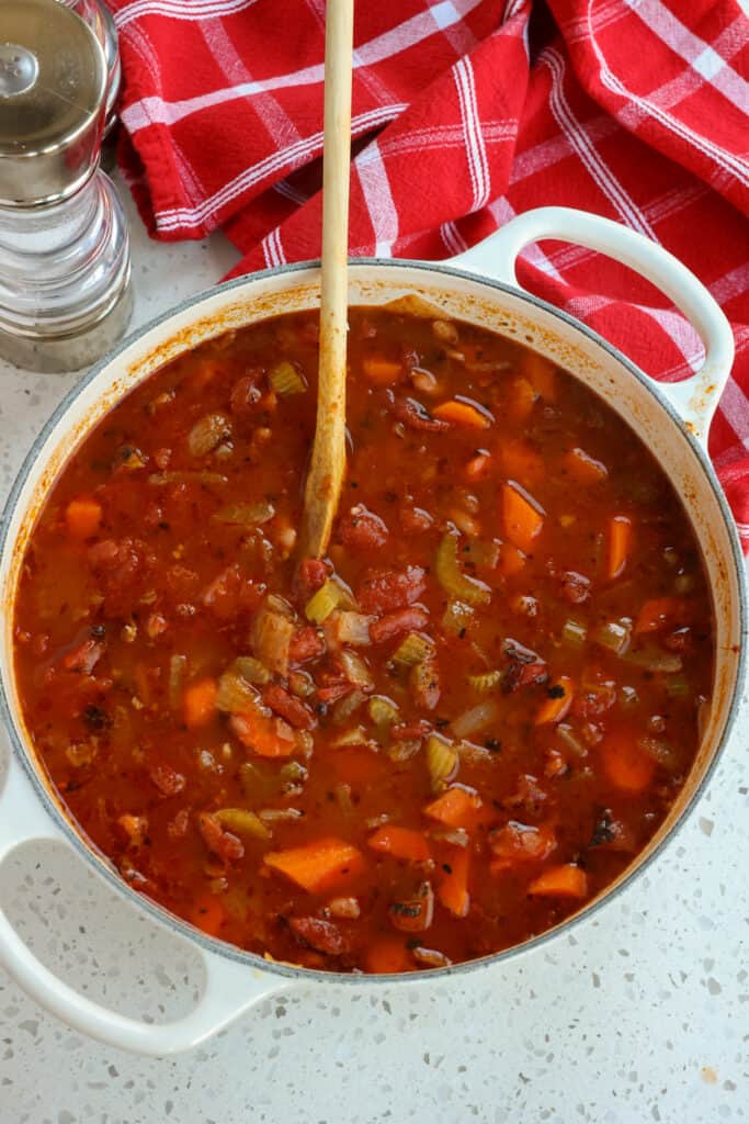 Add the vegetable broth, fire-roasted tomatoes, and bay leaves to the pot.