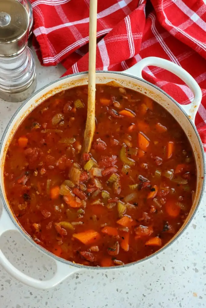 Add the vegetable broth, fire-roasted tomatoes, and bay leaves to the pot. 