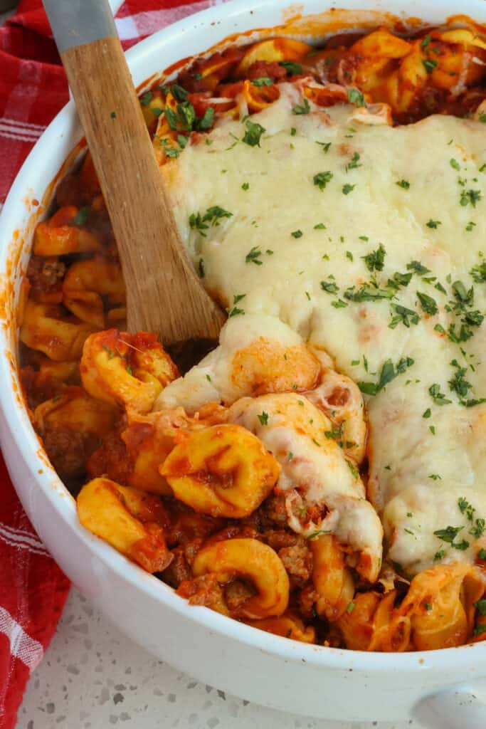 Easy Baked Tortellini combines refrigerated or frozen cheese tortellini with browned Italian Sausage, onions, and garlic, all drenched in marinara with oodles of Parmesan cheese and mozzarella cheese.