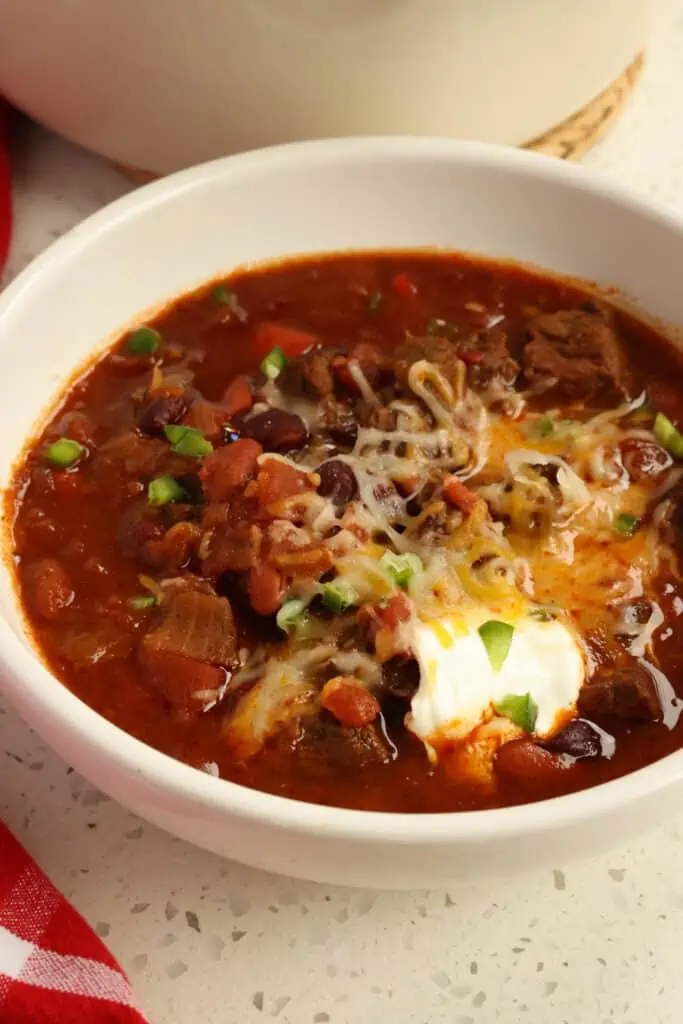 Delicious Chili Con Carne with tender bites of slow-cooked chuck roast, sweet onions, bell pepper, garlic, tomatoes, and dark red kidney beans in a well-seasoned rich broth. 