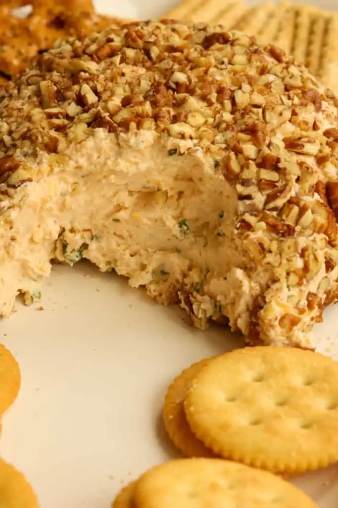 When ready to serve, take the cheese ball out of the fridge. Roll it in the chopped nuts and place it on a serving platter with your choice of goodies. 
