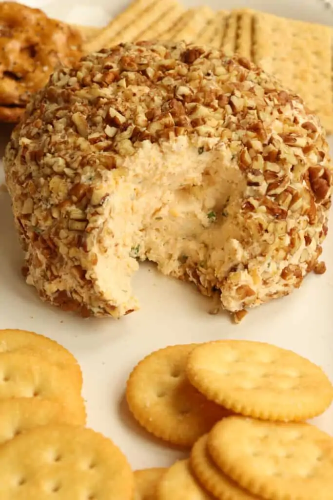 A classic cheese ball made with cream cheese, sharp cheddar cheese, green onions, and a few tasty spices combined and rolled in chopped pecans.