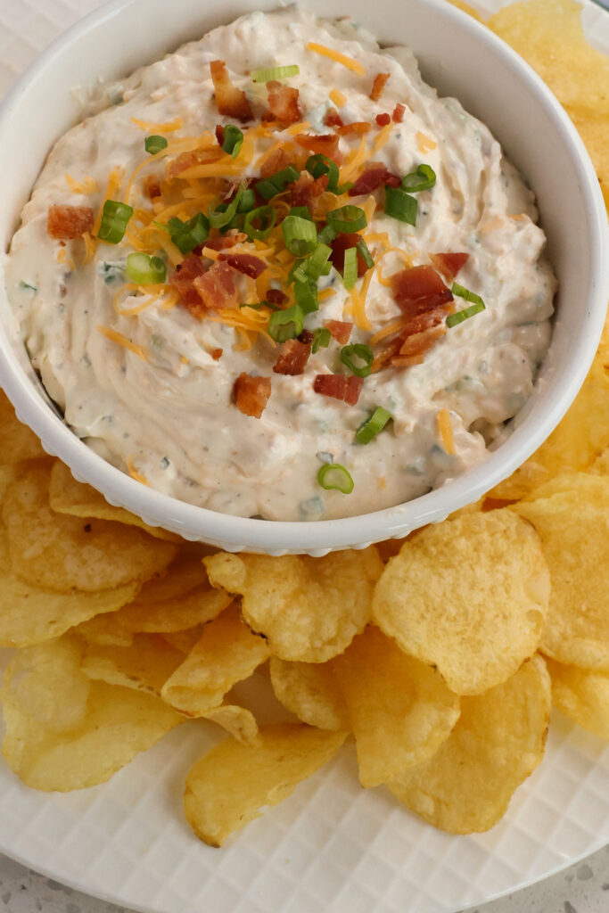Always a huge hit, this cream cheese-based Crack Dip is loaded with cheddar cheese, bacon, green onions, and ranch seasoning.  It is delicious on crackers, potato chips, pretzel crisps, Fritos, carrot sticks, celery sticks, or bell pepper wedges.
