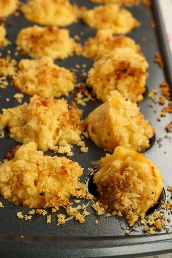 These baked Mac and Cheese Bites are tasty little cups of elbow macaroni in creamy cheddar cheese sauce topped with seasoned buttery Parmesan breadcrumbs.