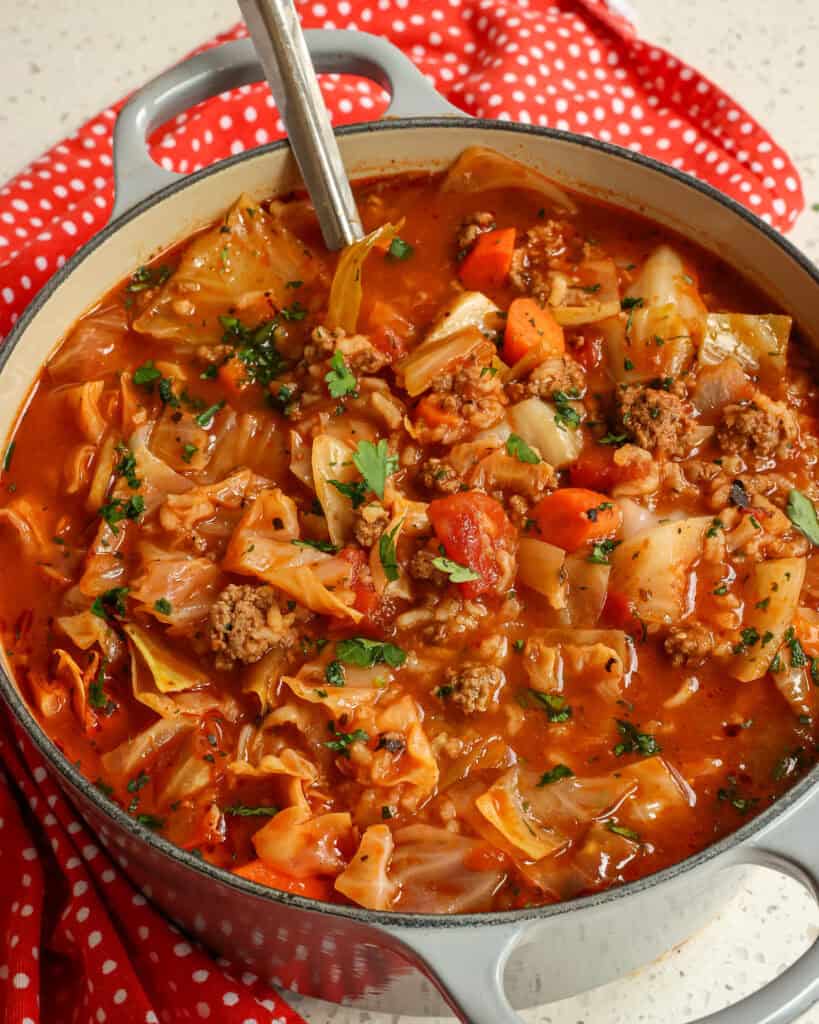 Over head view of cabbage roll soup with a ladle in the soup.