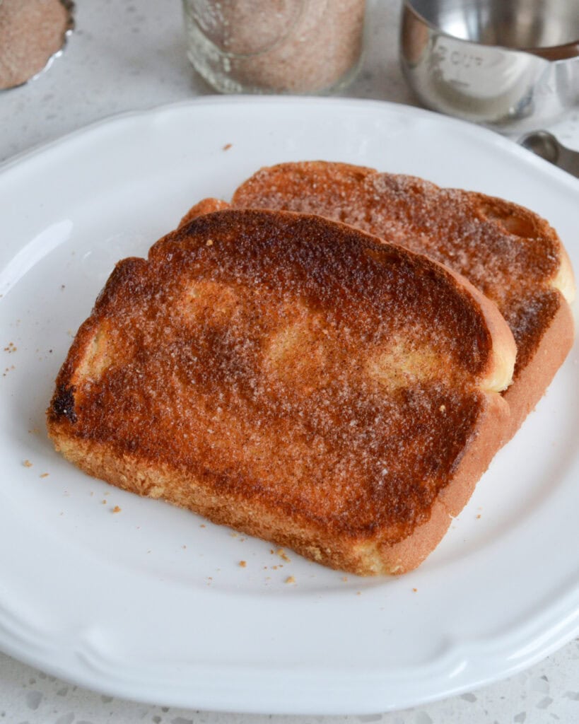 A serving plate with two pieces of cinnamon toast on it. 