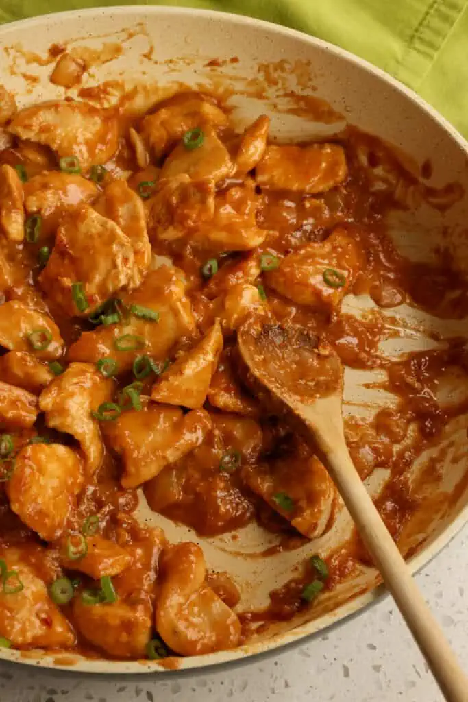 Add the chicken back to the skillet with the peanut sauce and warm for several minutes. Top with green onions and chopped peanuts. 