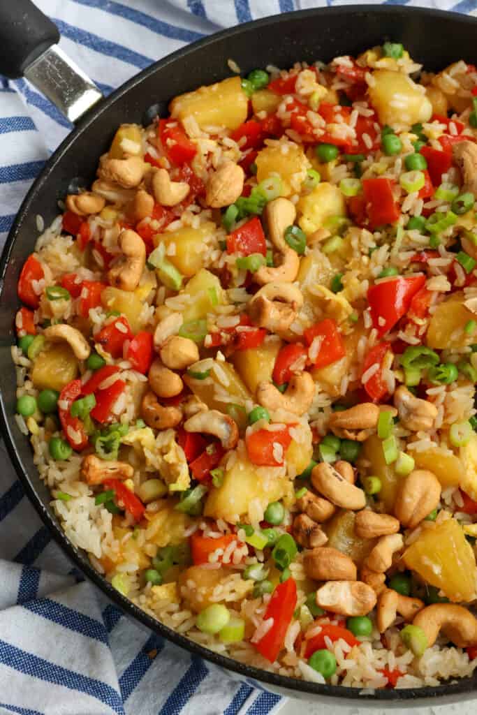 Delicious and easy Pineapple Fried Rice with red bell pepper, fresh pineapple, sweet peas, roasted cashews, green onions, and fried rice is drizzled with a sweet ginger sesame sauce. 