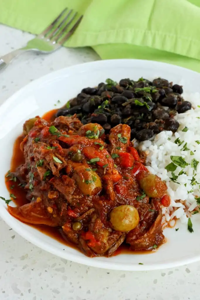 Ropa Vieja is a popular Cuban dish with tender slow cooked shredded beef, onions, bell pepper, olives, and capers in a rich tomato-based sauce that is loaded with flavor. 