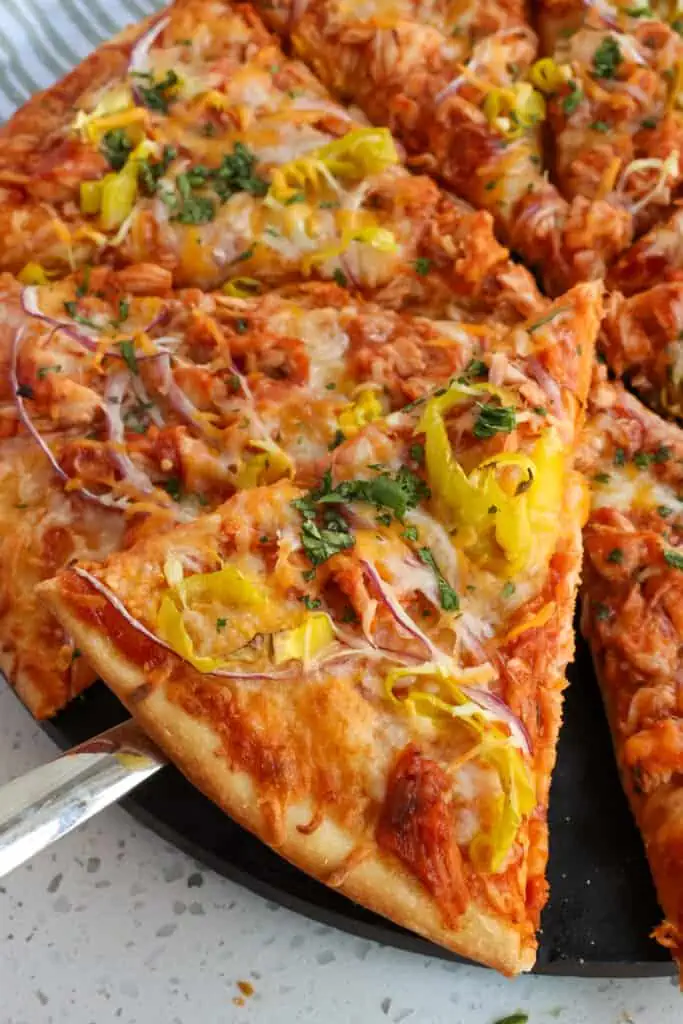 Deliciously simple Barbecue Chicken Pizza is made with your favorite barbecue sauce, rotisserie chicken, thin sliced red onion, and melty mozzarella and cheddar cheese. 